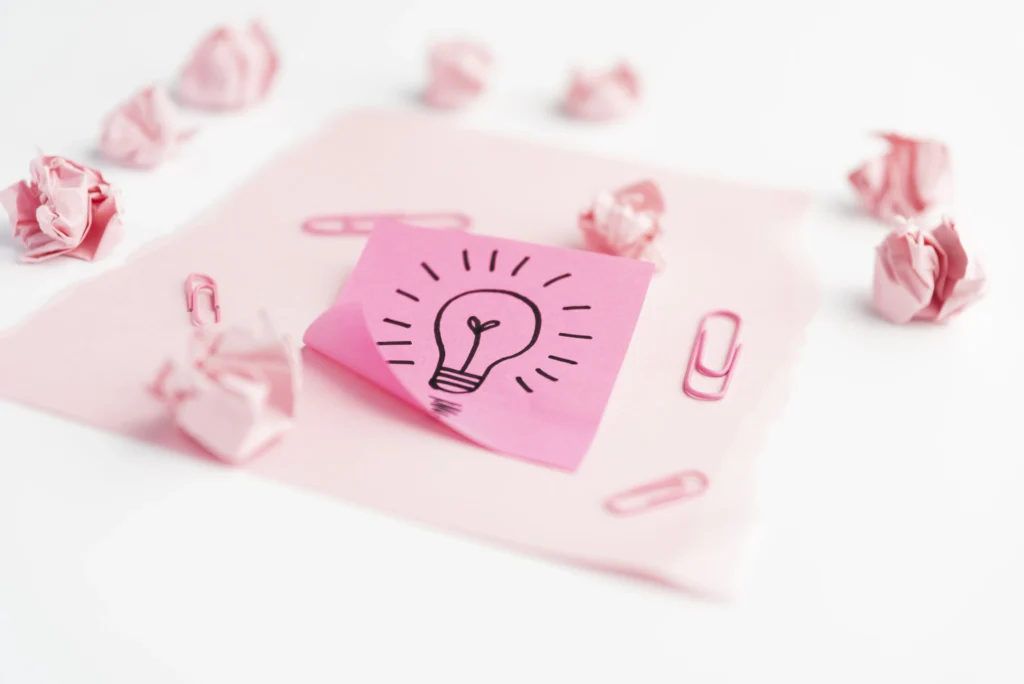 idea-icon-adhesive-note-with-paperclip-crumpled-paper-card-paper-white-desk